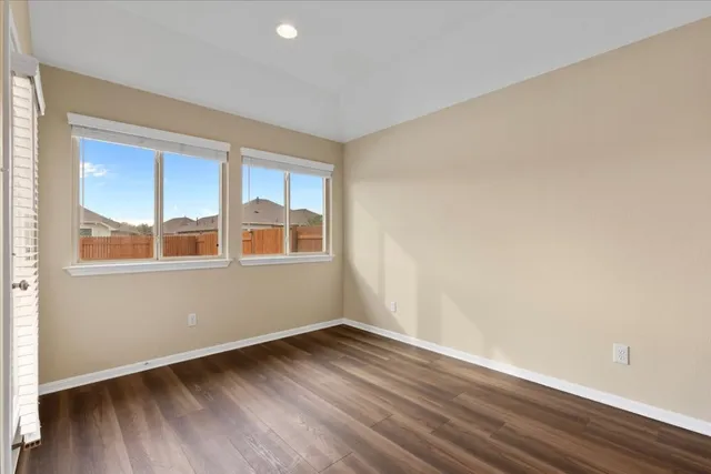 a big room with wooden floor and windows