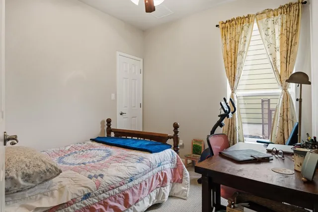 a bedroom with a bed and two windows