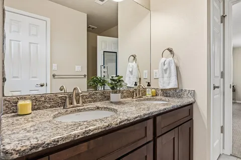 a bathroom with double sink and a mirror