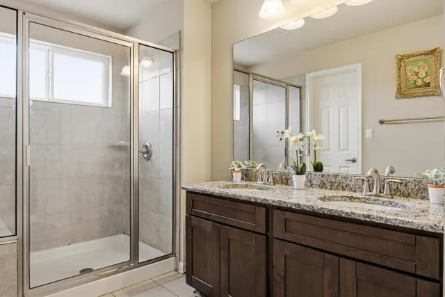 a bathroom with a granite countertop sink and a mirror