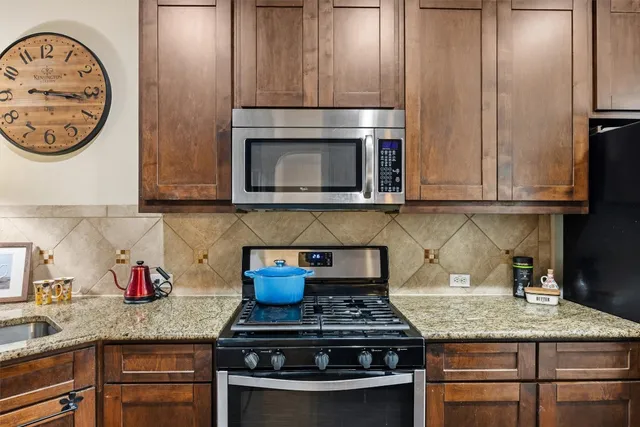 a kitchen with granite countertop stainless steel appliances stove and cabinets