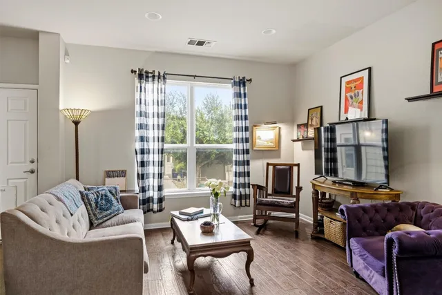 a living room with furniture a large window and a flat screen tv