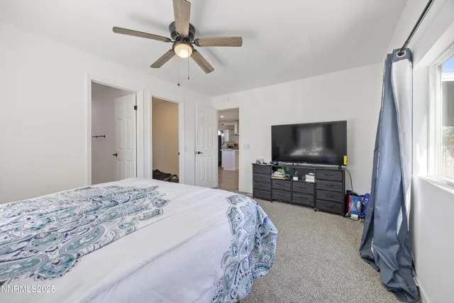 a spacious bathroom with a double vanity sink a toilet and a mirror