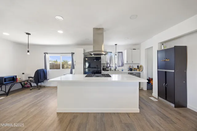 a kitchen that has a lot of cabinets a sink and appliances in it