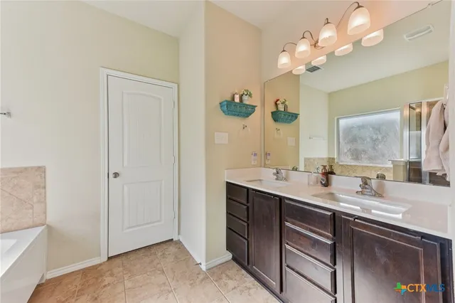 a bathroom with a double vanity sink and a mirror