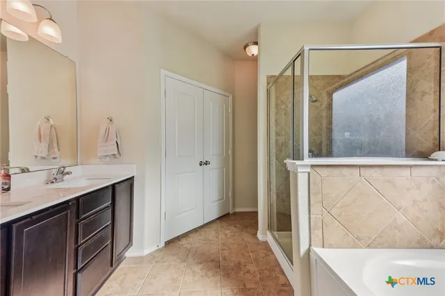 a bathroom with a granite countertop sink a mirror and a shower
