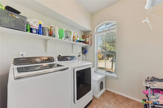 a utility room with dryer washer and a fridge