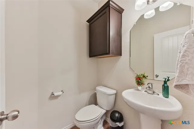 a bathroom with a toilet a sink and mirror