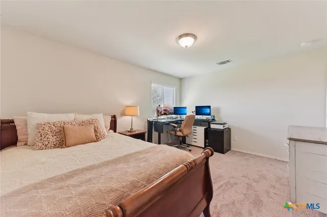 a bedroom with a bed and a computer on a table