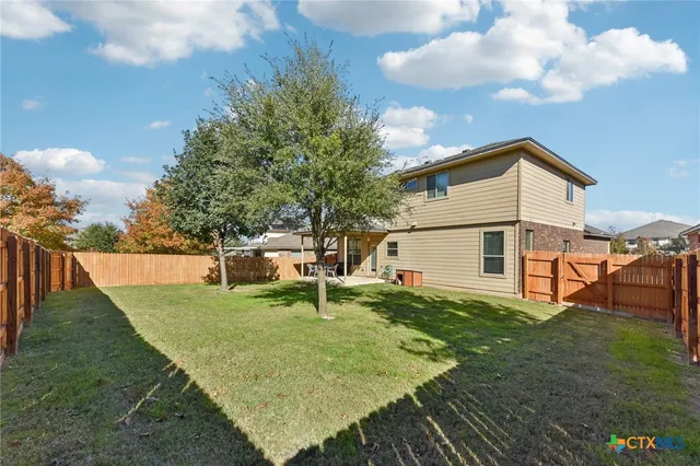 a view of a house with backyard and sitting area