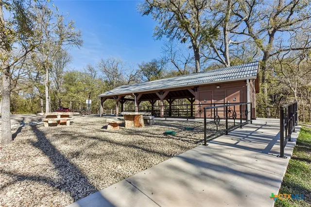 a view of a house with large trees and wooden fence