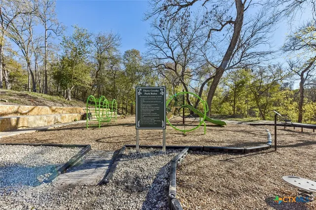 a backyard of a house with table and chairs under an umbrella