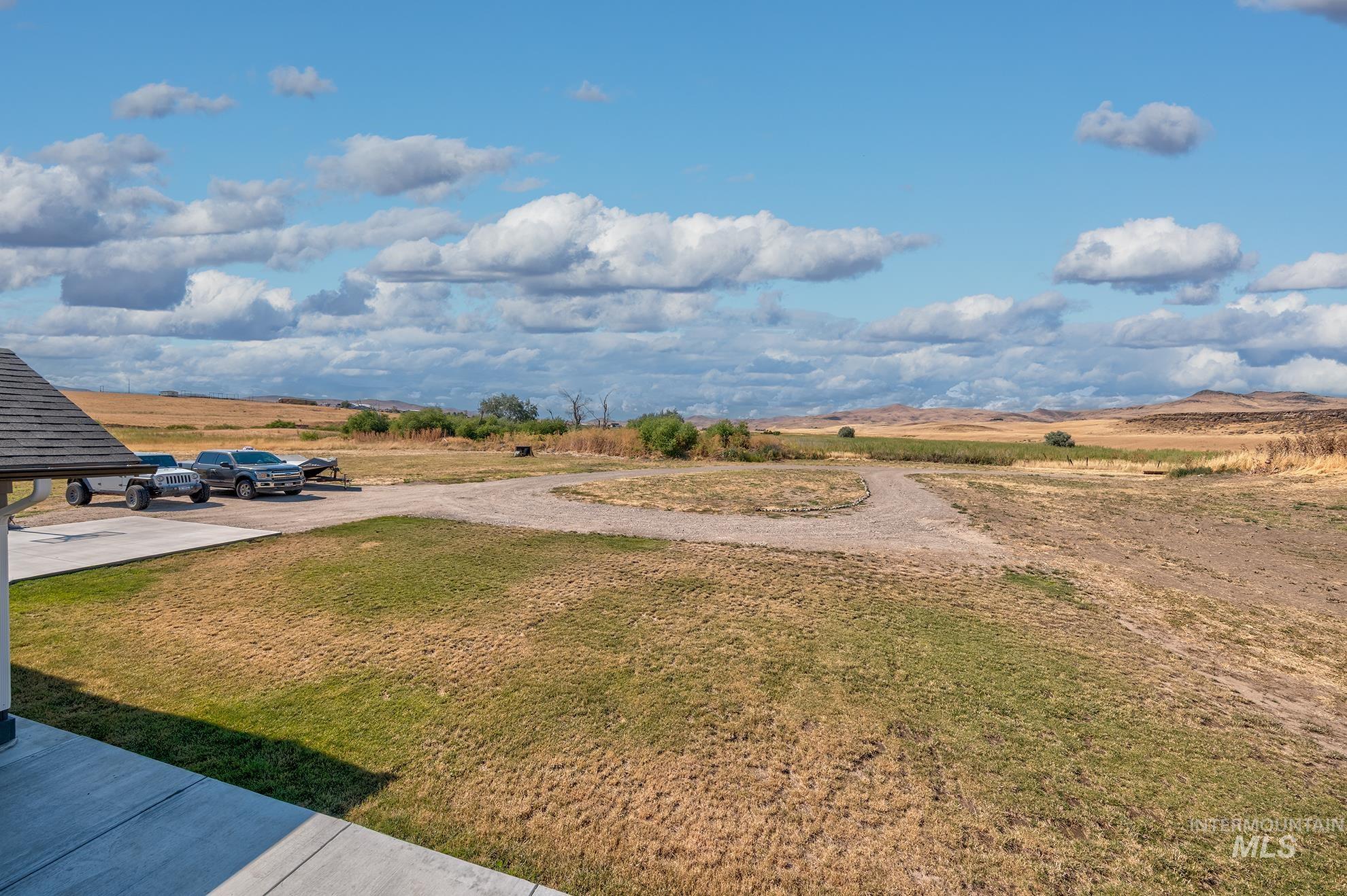 1049 Price Road Weiser, ID 83672 - Photo 35 of 47 Expansive rural landscape featuring a gravel driveway, natural terrain, and distant hills