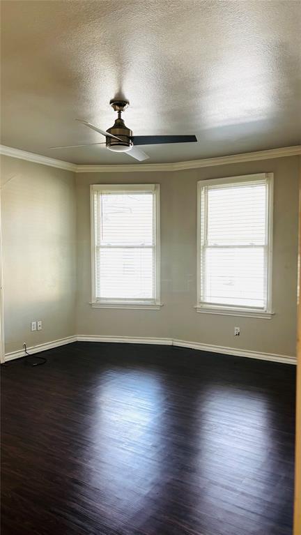 4511 Junius Street Dallas, TX 75246 - Photo 9 of 16 Bay window area with two double-hung windows, dark wood-finish flooring, crown molding, and a ceiling fan with integrated lighting