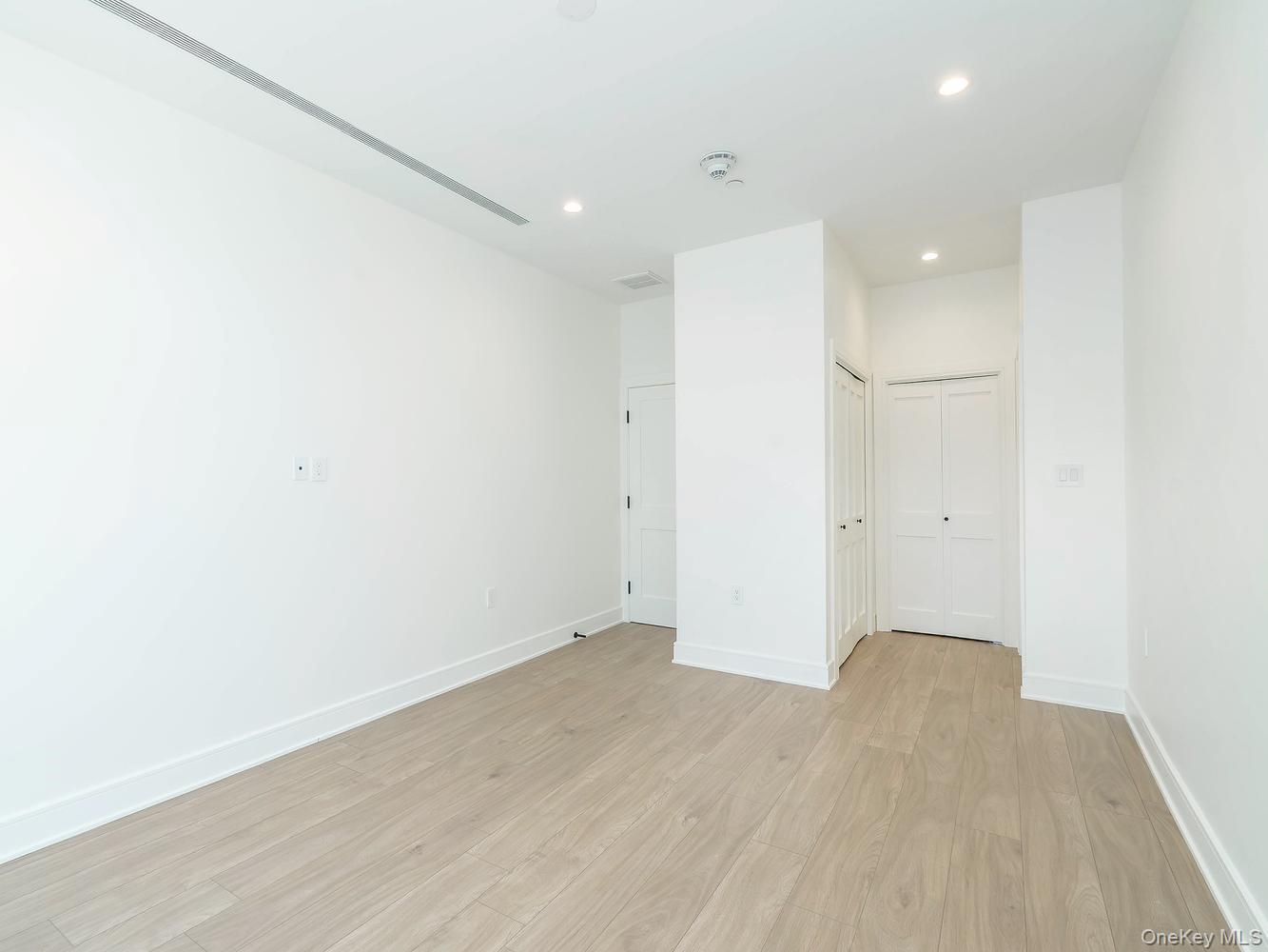24 Lumber Road, Unit 1 Roslyn, NY 11576 - Photo 16 of 18 an empty room with wooden floor and windows