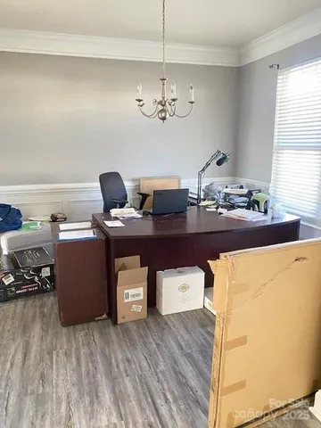 a view of a workspace with furniture and a window