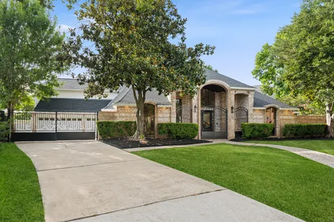 a front view of a house with a yard and trees