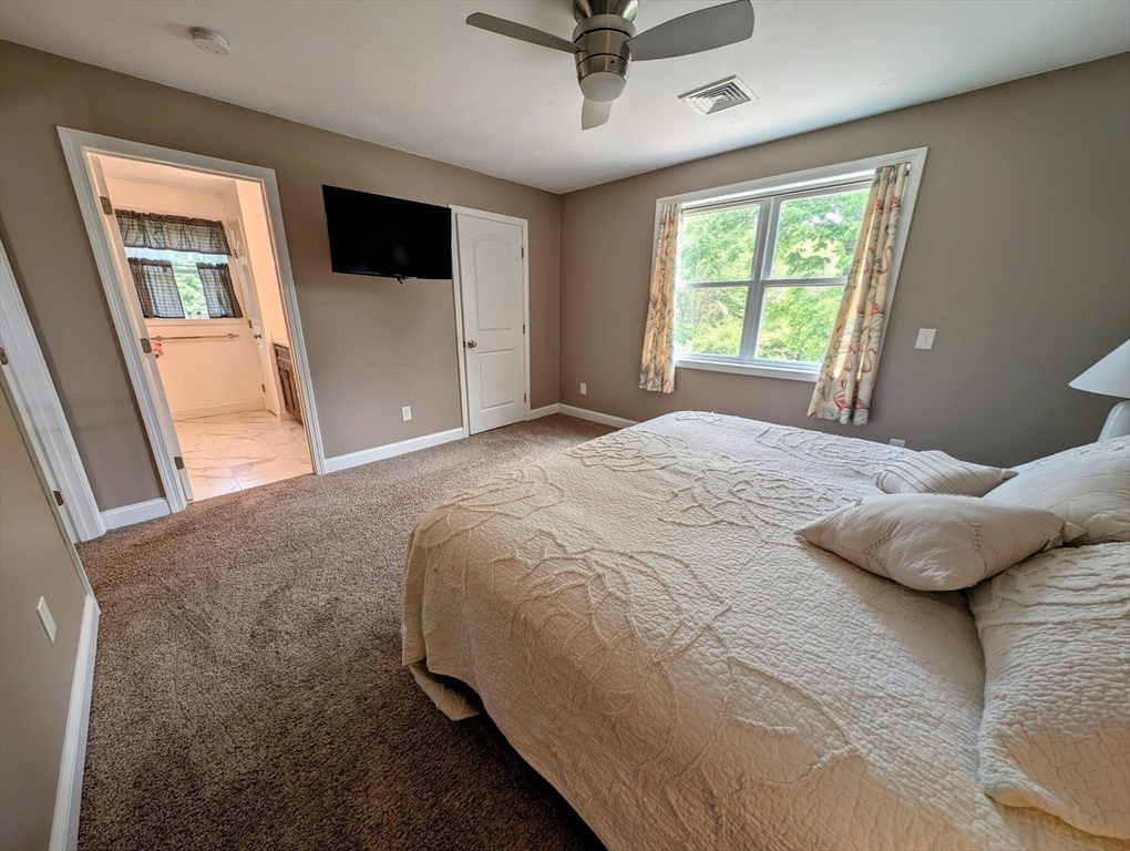 74 Baker Pond Road Dudley, MA 01571 - Photo 13 of 42 a bedroom with a bed and a flat tv screen on dresser