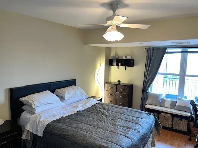 a bedroom with a bed and a dresser next to a window