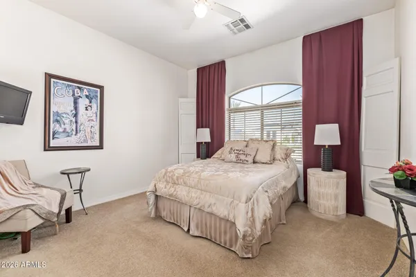 a bedroom with a bed mirror and window