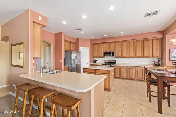 a kitchen with stainless steel appliances granite countertop a stove a sink a refrigerator and a refrigerator