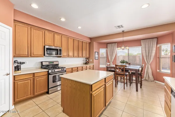 a kitchen with sink a stove and chairs