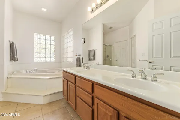a bathroom with a sink double vanity mirror and a bathtub