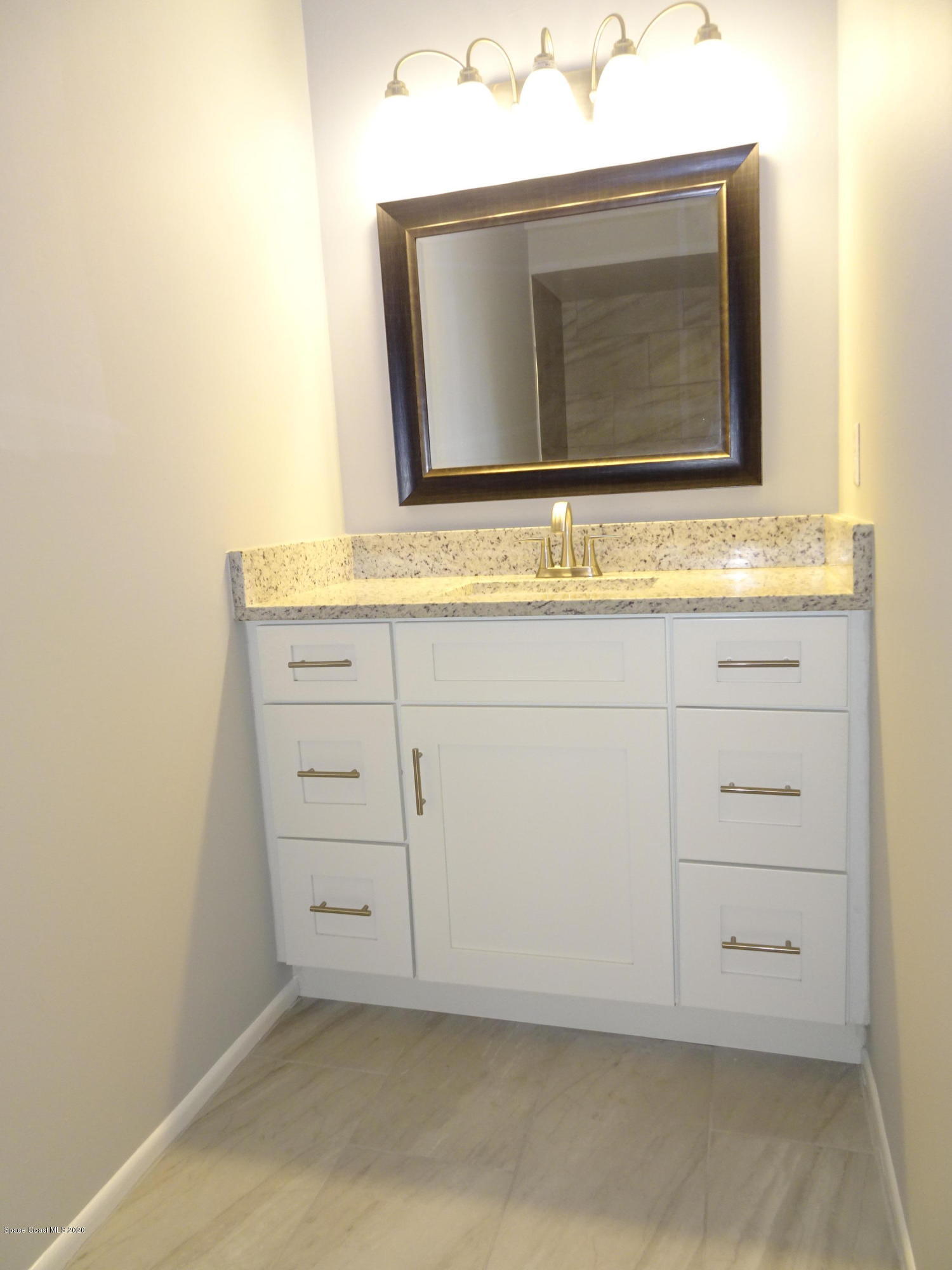 4875 Sisson Road Titusville, FL 32780 - Photo 10 of 14 a bathroom with a sink and a mirror
