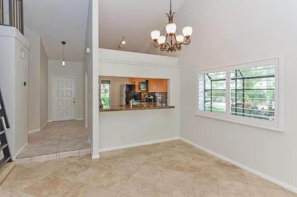 an empty room with chandelier and windows
