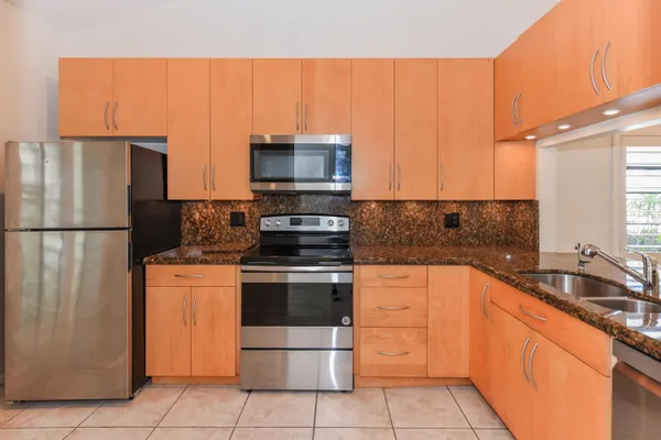 a kitchen with stainless steel appliances granite countertop a refrigerator sink and stove