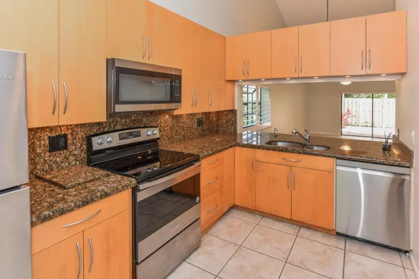 a kitchen with stainless steel appliances granite countertop a stove a sink and a microwave