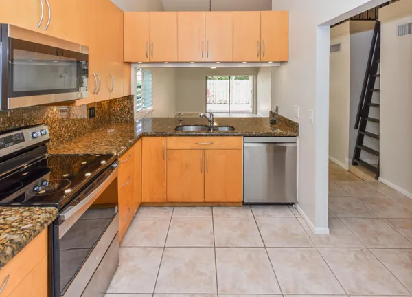 a kitchen with stainless steel appliances granite countertop a stove a sink and a microwave
