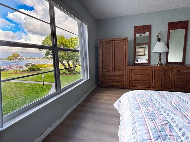 a bedroom with a bed and a large window with outer view