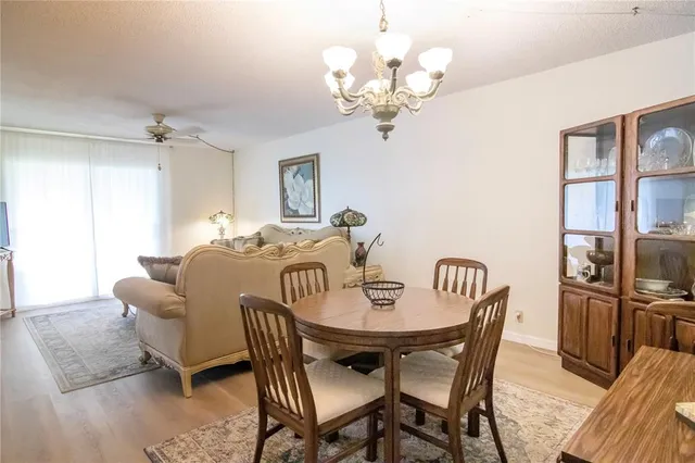 a view of a dining room with furniture a chandelier and wooden floor