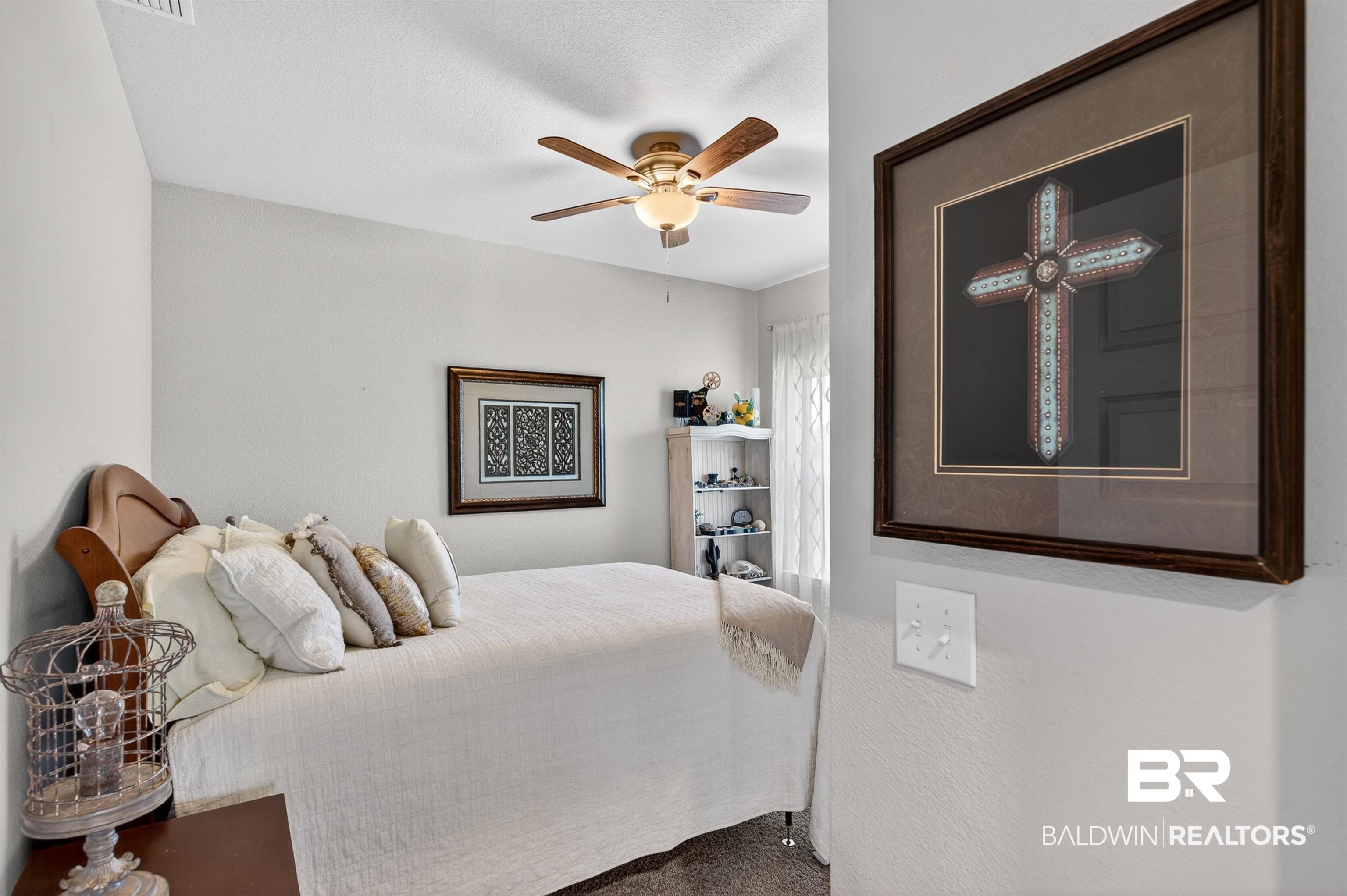 8735 Bronze Lane Foley, AL 36535 - Photo 28 of 58 Recessed bedroom featuring light gray wall paint, wood-finish ceiling fan with integrated lighting, and a window with sheer curtain treatments