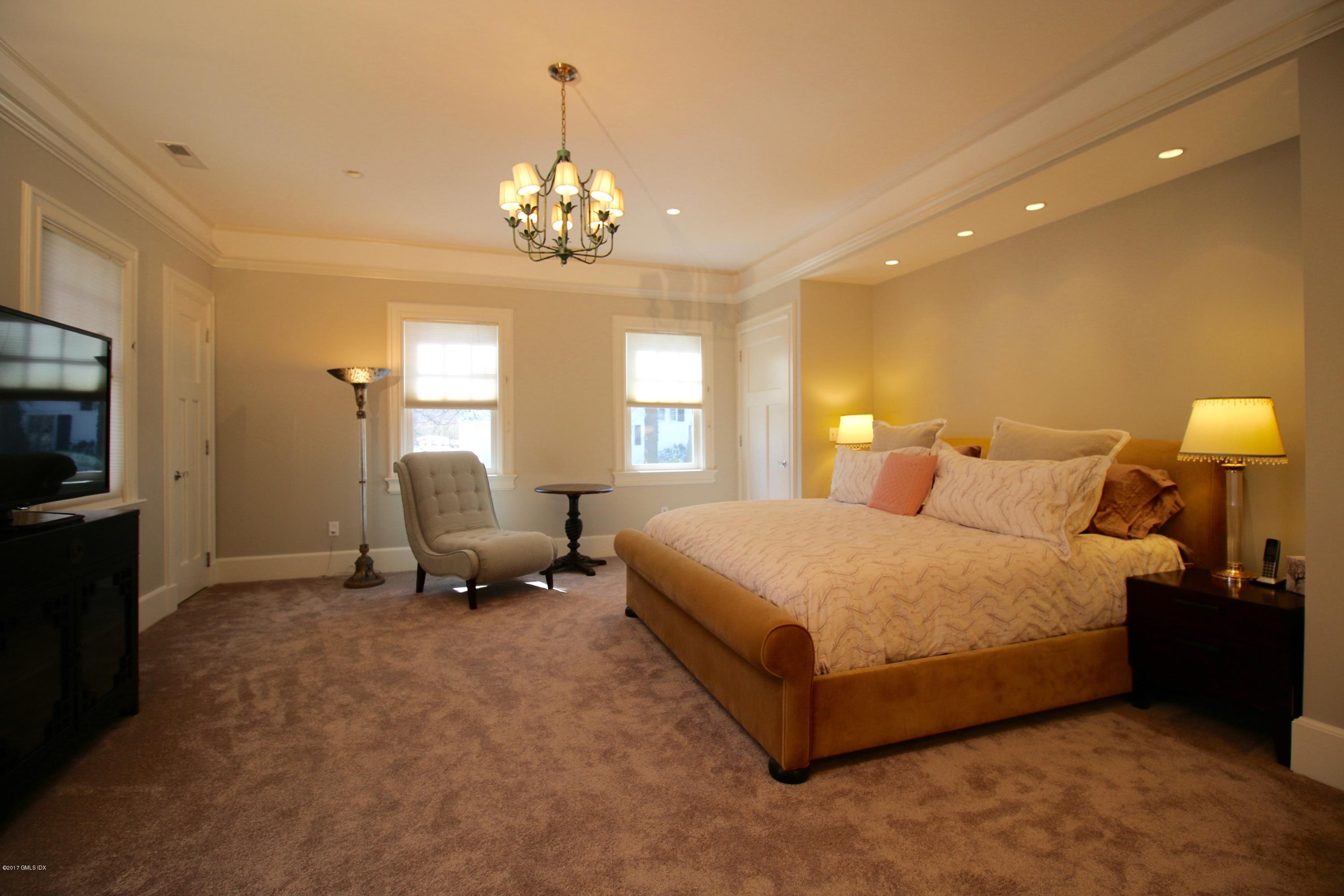 57 Indian Field Road Greenwich, CT 06830 - Photo 13 of 24 a spacious bedroom with a bed and a chandelier