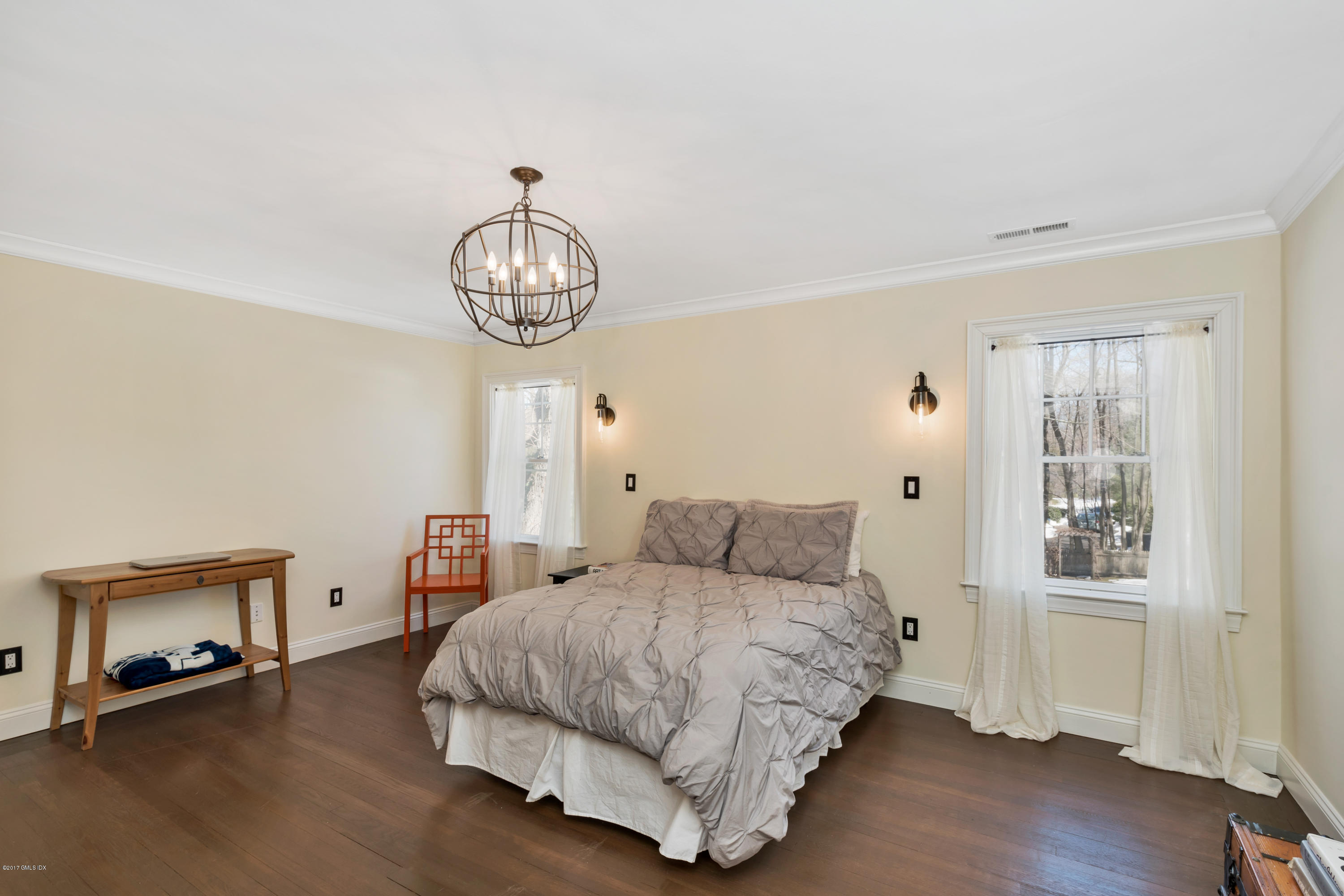 57 Indian Field Road Greenwich, CT 06830 - Photo 19 of 24 a bedroom with a bed and a chandelier