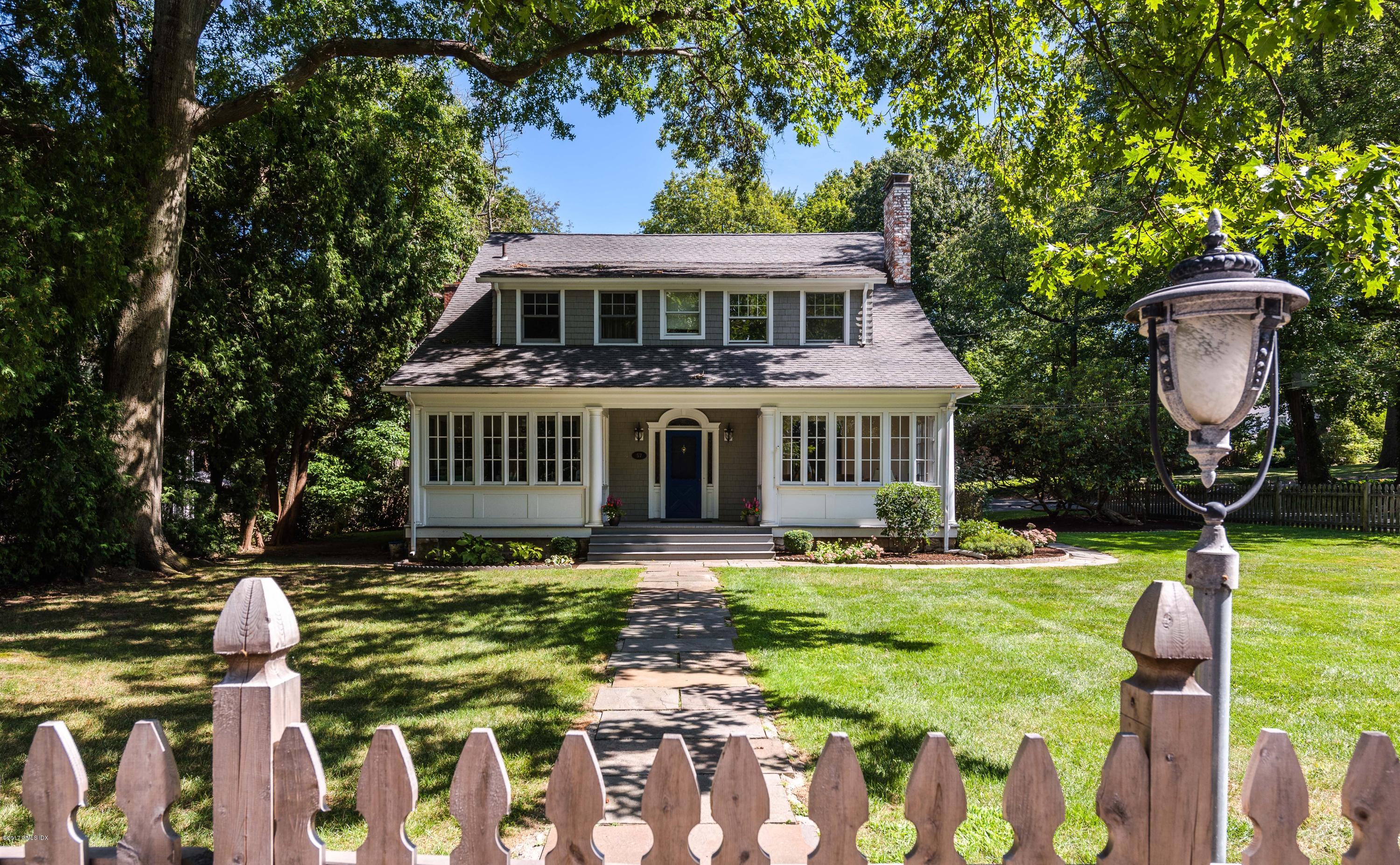 57 Indian Field Road Greenwich, CT 06830 - Photo 2 of 24 a front view of a house with a yard table and chairs