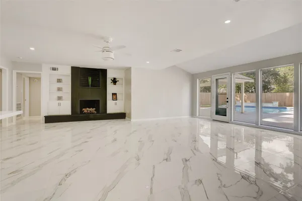 a view of an empty room with a fireplace and a large window