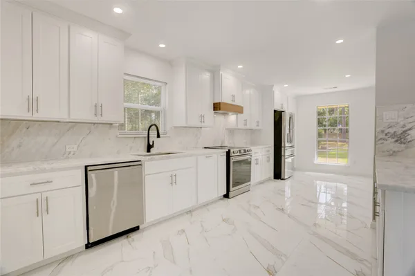 a kitchen with white cabinets and sink