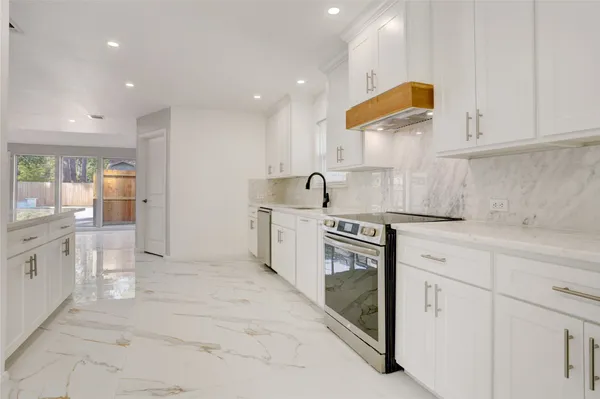 a kitchen with white cabinets and sink