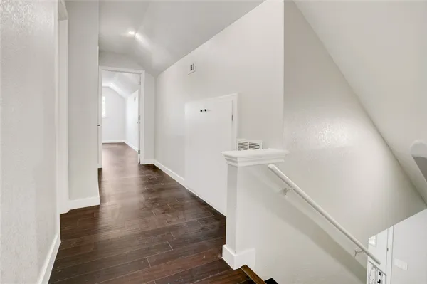 a view of a hallway with wooden floor and entryway