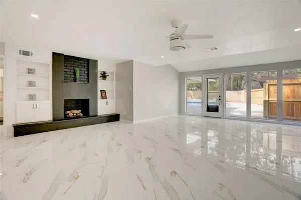 a view of an empty room with a fireplace and a window