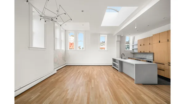 a large kitchen with a wooden floor and stainless steel appliances