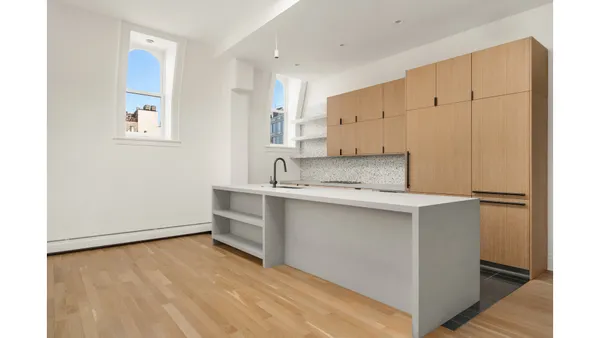 a kitchen with a refrigerator and white cabinets