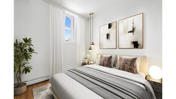 a bedroom with a bed and a potted plant