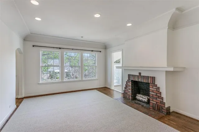 an empty room with fireplace and windows