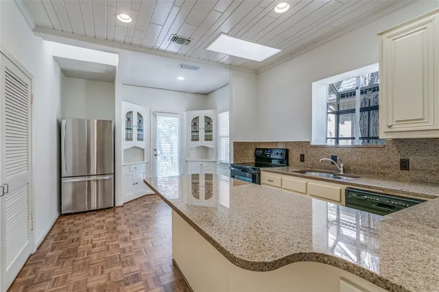 a kitchen with stainless steel appliances granite countertop a sink a stove and a refrigerator
