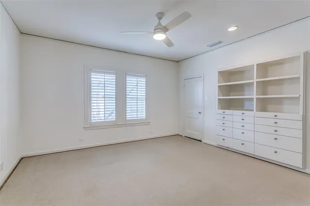 an empty room with windows and cabinet