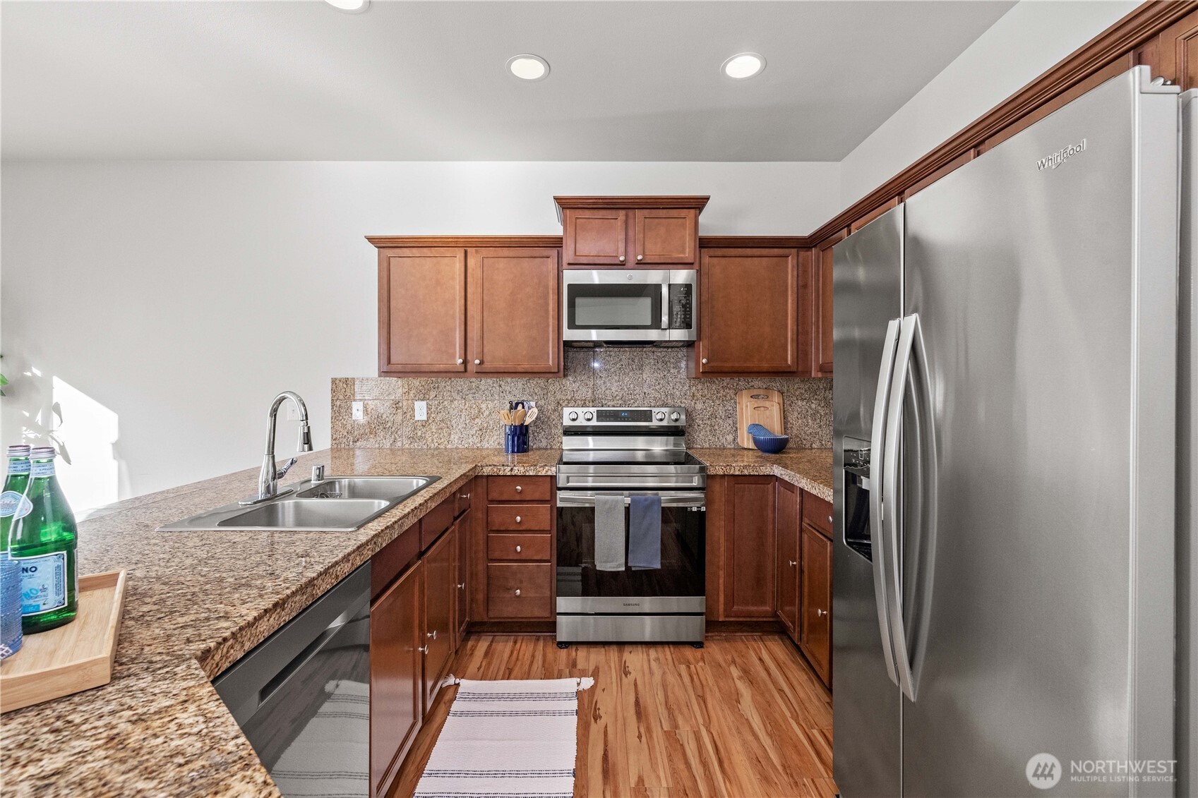 26219 243rd Place Southeast Maple Valley, WA 98038 - Photo 11 of 40 a kitchen with stainless steel appliances granite countertop a refrigerator stove and sink